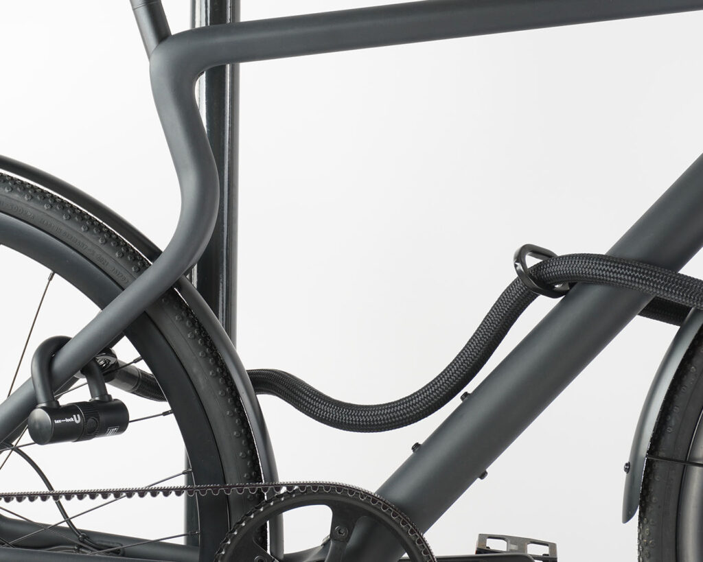 Bügelschloss mit Verlängerung aus Textil in schwarz sichert Vorder-, Hinterrad und Rahmen gleichzeitig am Fahrradständer ab