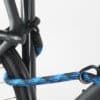 Bügelschloss mit Verlängerung aus blau-schwarzem Textil sichert drei Fahrrad-Komponenten gleichzeitig am Fahrradständer ab