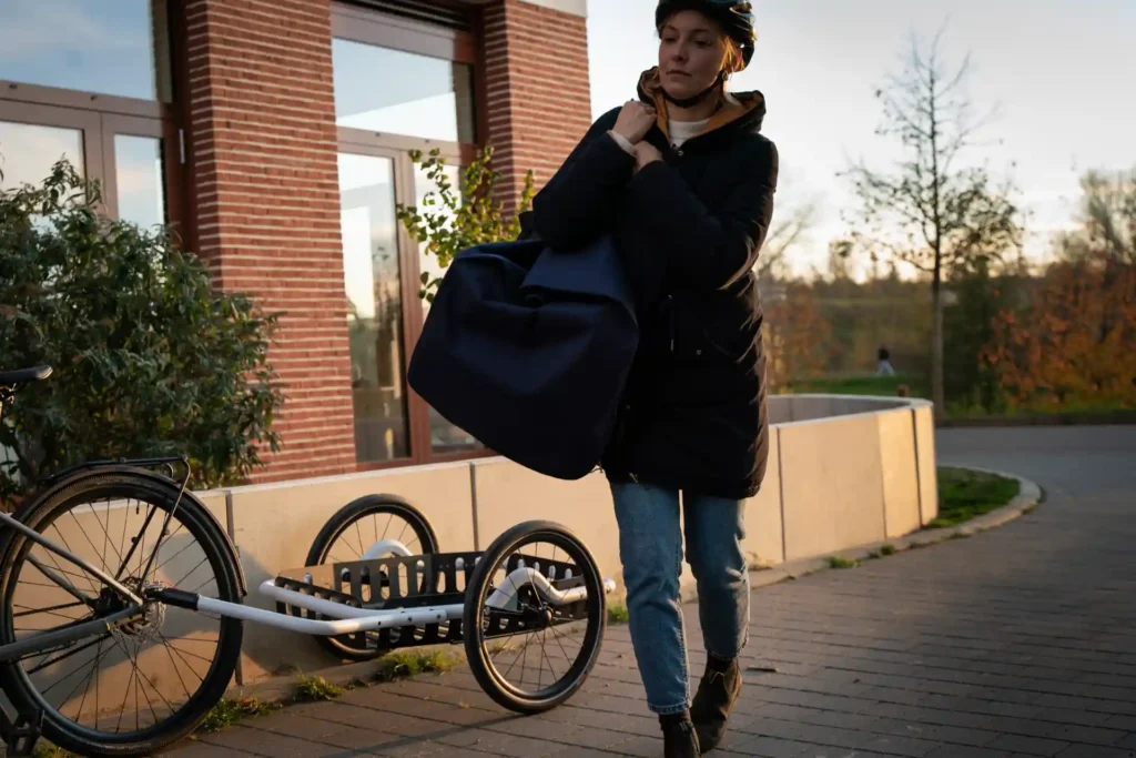 Woman carrying large bag from bicycle trailer